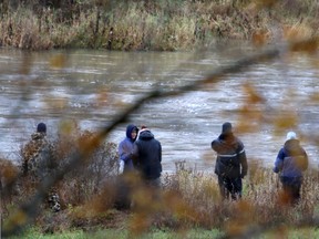 People including relatives stand on the bank of the Sauble River, south of Park Head, on Saturday, October 26, 2013 while an OPP Underwater Search and Recovery Team  search the river for a missing boater.  The team used side scanning radar during the search. (The Sun Times\JAMES MASTERS\QMI Agency).