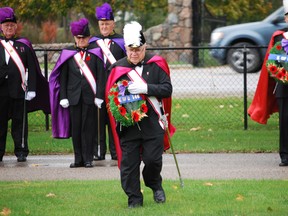 John Loehndorf of  Fr. Ernie Deslippe Council 1467 of the Knights of Columbus lays a wreath at the base of a Canadian flag at Holy Angels' Cemetery in St. Thomas on Saturday. The wreaths were part of a ceremony meant to honour veterans from the community who died in war. Ben Forrest/QMI Agency/Times-Journal