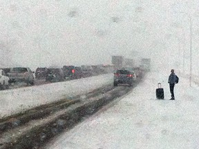 A man is stranded on the side of the highway.  Cars move slowly on the Queen Elizabeth Highway on Sunday.  A snow storm will drop approx. 20 cm of snow south of Edmonton.    Photo By Edward Dawson/Edmonton Sun/QMI Agency