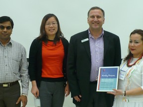 From left, WorleyParsons employees Alkesh Shah, project engineer, Annie Zhang, project engineer, and Joel Regenstreif, business unit general manager, receive the YMCA Cultural Diversity the Workplace Award from YMCA English student Brenda Castillo. 
SUBMITTED PHOTO