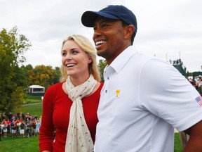 Tiger Woods celebrates with his girlfriend, Lindsey Vonn, after defeating International player Richard Sterne of South Africa to win the Presidents Cup at Muirfield Village Golf Club in Dublin, Ohio October 6, 2013. (REUTERS/Jeff Haynes)