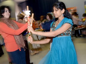 Purvi Shah, right, helps teach an Indian stick dance to visitors to the Windows to the World open house celebrating english as a second language organized by Loyola School of Adult and Continuing Education in Belleville, ON. Tuesday, Oct. 22, 2013. The week of Oct. 20 to 26 was proclaimed as ESL week across the Quinte region. 
EMILY MOUNTNEY/THE INTELLIGENCER/QMI AGENCY