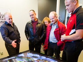 Ottawa Red Blacks President Jeff Hunt (L) explains details of the Lansdowne project to fans John Heward (2nd from right) along with his daughter Susan and son Patrick, at the Ottawa Sports and Entertainment Group (OSEG) Stadium Preview Centre on Tuesday October 29,2013. The Hewards were one of the first to select their football season ticket seats. 
Errol McGihon/Ottawa Sun/QMI Agency