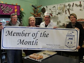 Board of Trade Director, Mark Johnson (far left), and Board of Trade employee Julia Martin (far right), presenting Mike and Marilyn Pouliot (center) with their 'Member of the Month' banner.