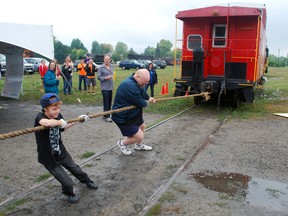 Connor Claus, 13, of St. Thomas and event marshal Len Elliott help pull a 100,000-lb train caboose at the Elgin County Railway Museum. Teams of people collected pledges for the Elgin-St. Thomas United Way and then took turns pulling the caboose to help launch the United Way's 2013 fundraising campaign. This year's campaign goal is $620,000.