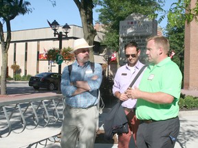 Carson Warrener of the Downtown Chatham Centre, right, talks to Communities in Bloom judges Robert Ivison, left, and Alain Cappelle about the improvements that have been made to the property during judging on July 25.