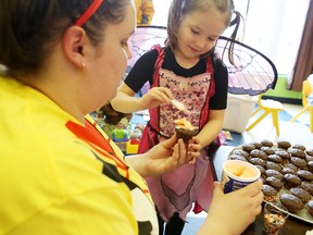 Child care worker Jessica Benn helps Amelia Belisle-Johnson, 5, ice a cupcake at the Playtrium Daycare, which closed Thursday.        
Elliot Ferguson The Whig-Standard