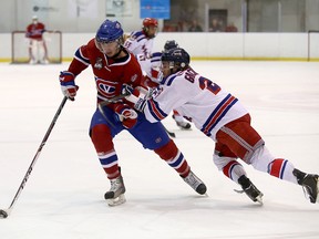 Kingston Voyageurs’ Cole Bolton tries to drive wide on North York Rangers’ Michael Giacometti during Ontario Junior Hockey League action at the Invista Centre Thursday night. (Ian MacAlpine/The Whig-Standard)