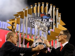 MLB commissioner Bud Selig presents the Boston Red Sox owner with the Commissioner's Trophy after the Sox won the 2013 World Series. Isn't there something wrong with the owner being the first one to touch the award?  (Getty Images/AFP)
