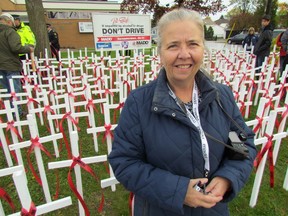 Natalie Leduc, with MADD Sarnia-Lambton, stands Saturday in Point Edward next to 200 crosses set up as part of the organization's annual Project Red Ribbon. The crosses represent the typical number of Canadian killed during the holidays by impaired drivers. PAUL MORDEN/THE OBSERVER/QMI AGENCY
