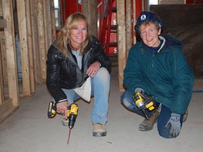 Joelle Jackson, left, of the Canada Mortgage and Housing Corporation and City of St. Thomas social housing administrator Elizabeth Sebestyen helped fasten down a sub floor at Habitat for Humanity's first-ever St. Thomas build on Monday, Oct. 28, 2013. Habitat expects to finish the home by the end of January. Ben Forrest/QMI Agency/Times-Journal