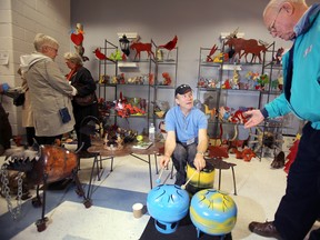 Uxbridge, Ont. artist Jean-Pierre Schoss talks about his "bongos", which he made from 20-lbs propane tanks, with a visitor at the 10th annual Maker's Hand show and sale at Prince Edward Community Centre in Picton, Ont. Saturday, Nov. 2, 2013. -  JEROME LESSARD/The Intelligencer