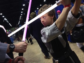 Eleven-year-old Nathan Robertson shows off his light saber fighting technique at the Central Canada Comic Con in Winnipeg, Man., on Nov. 2, 2013. (DANIELLA PONTICELLI/WINNIPEG SUN/QMI Agency)