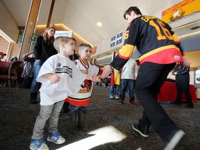 Brothers Caleb (left) and Cole White of Belleville, Ont. share a high five with Belleville Bulls players during the 5th annual Breakfast with the Bulls in August 2014.- FILE/JEROME LESSARD/The Intelligencer