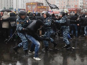 Riot police detain a participant for violation of law and order during a "Russian March" demonstration on National Unity Day in Moscow November 4, 2013. (REUTERS/Maxim Shemetov)