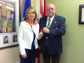 Poppy Campaign Chair and Drayton Valley Royal Canadian Legion President Reg Hamilton presents a poppy to Drayton Valley/Devon MLA Diana McQueen at the start of the annual poppy campaign. Poppies are now available at businesses throughout the area.