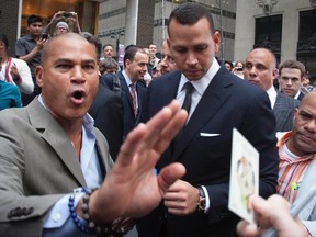New York Yankees baseball player Alex Rodriguez (C) is surrounded by supporters after leaving Major League Baseball's headquarters in New York, October 4, 2013. (REUTERS)