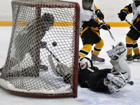 Connor Lockhart of the Mitchell Atoms watches his shot bounce into the open net over the prone Mount Forest goalie during WOAA regular season action last Friday, Nov. 1. Lockhart’s goal clinched a 4-1 win. ANDY BADER/MITCHELL ADVOCATE
