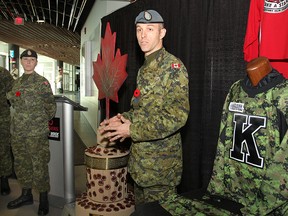 Sgt. Greg Huizinga, a member of the team that created the monument, at centre, to remember Canadian military personnel killed in Afghanistan, talks about the project during a press conference at the Rogers K-Rock Centre Monday that also unveiled the camouflage jerseys, at right, that the Kingston Frontenacs will be wearing Friday night. At left is Warrant Officer Renay Groves, the leader of the monument team.
Michael Lea The Whig-Standard