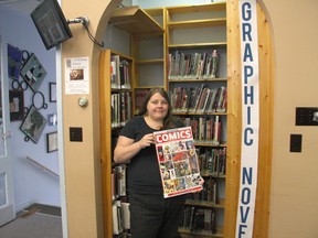 Liz Zylstra of the Prince Edward County Public Library shows off one of the many titles in the adult graphic novel section at the Picton branch. A discussion group meets the second Wednesday of each month to explore the world of graphic novels and comics for adults.