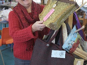 Marilyn Trudeau, president of the Kingston Handloom Weavers and Spinners, looks at a handbag made of old VHS tapes, one of the more unusual items that will be for sale during this weekend's annual fall sale.
Michael Lea The Whig-Standard