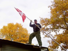 A member of Larry Oakley's hunting camp, located near Kaladar, helps raise a new flag that is flown year round. The hunters also wear poppies during the hunting season that starts in November.
Supplied photo