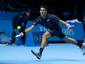Novak Djokovic hits a return to Roger Federer during their match at the ATP World Tour Finals at the O2 Arena in London November 5, 2013. (REUTERS/Eddie Keogh)