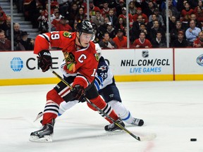 Nov 6, 2013; Chicago, IL, USA;  Chicago Blackhawks center Jonathan Toews (19) is defended by Winnipeg Jets defenseman Tobias Enstrom (39) during the first period at the United Center. Mandatory Credit: David Banks-USA TODAY Sports