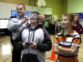Corporal Jason Pinder of the RCMP shows Michael Butler what it's like to drive after having a few drinks.  Butler along with hundreds of other students had the chance to play a video game both "sober" and with blurred vision. This simulation was part of many initiatives at the annual "Racing Against Drugs" initiative developed by the RCMP. (MELANIE ANDERSON, The Observer)