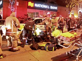 Emergency personnel come to the aid of a cycist who ended up under police cruiser overnight. (JOHN HANLEY/Special to the Toronto Sun)