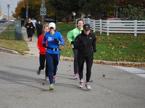 Terri Biloski (foreground, second from left) makes her way down Fairview Ave. in St. Thomas Saturday, just after beginning a 161 km run around Elgin county. The run is meant to raise money for research and awareness of Huntington Disease. Ben Forrest/Times-Journal