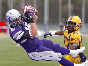 Western Mustangs wide receiver Matt Uren makes an airborne touchdown catch as Queens Gaels defensive back T.J. Chase-Dunawa watches during the 106th OUA Yates Cup at TD Stadium in London, Ont. on Saturday. CRAIG GLOVER/The London Free Press/QMI Agency