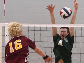 Regiopolis-Notre Dame's Greg Borschneck hits the ball through the hands of Nicholas Boutilier of Holy Cross during Sunday's KASSAA senior boys volleyball championship at Queen's University. (Elliot Ferguson/The Whig-Standard)