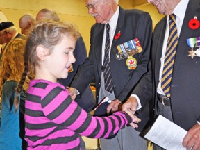 Shelby Vanderhyden shakes the hand of veteran Bill Cornish to say thank you for their service and sacrifice during the First and Second World Wars this past Sunday, Nov. 10, at Upper Thames Missionary Church in Mitchell. The church welcomed veterans and their families for a special Remembrance Day church service on Sunday, one day prior to the official Remembrance Day ceremony held at the Mitchell & District Community Centre. KRISTINE JEAN/MITCHELL ADVOCATE