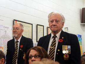 Two veterans stand up to be recognized during the service inside the legion hall.