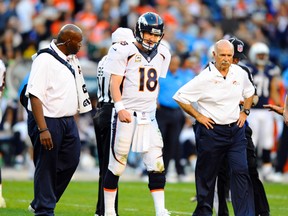 Broncos QB Peyton Manning (18) is looked at by members of the medical staff after being hit on a pass play during second half action against the Chargers in San Diego on Sunday, Nov. 10, 2013. (Christopher Hanewinckel/USA TODAY Sports)