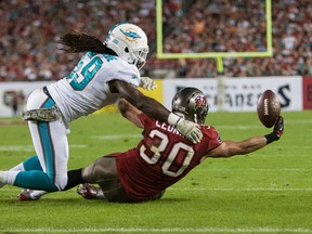 Dolphins' Dannell Ellerbe (left) defends against Bucs running back Brian Leonard as he reaches for a pass during first half NFL action in Tampa, Fla. (Rob Foldy/USA TODAY Sports)