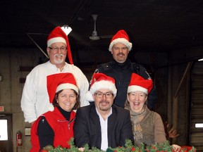 Santa's recently refurbished sleigh holds (front row, from left) Sudbury Santa Claus Parade committee member Cathy Carrier, Sudbury Star publisher and float judge David Kilgour, Downtown Sudbury executive director and committee media liaison Maureen Luoma, (back row) committee chair Bob Fennell and Const. Rick Carr, of the Greater Sudbury Police Service's traffic unit, following a press conference on Tuesday. Ben Leeson/The Sudbury Star/QMI Agency