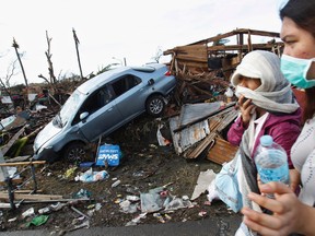 People covering their faces pass a car in debris after super typhoon Haiyan battered Tacloban City, in central Philippines. Philippine officials have been overwhelmed by Haiyan, one of the strongest typhoons on record.
REUTERS/Edgar Su