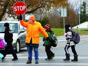 School crossing guard Millie Lacasse escorts a group of elementary students safely across the road. (QMI Agency file photo)
