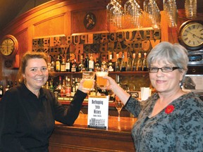 Cheryl Radford, left, and Kym Wolfe, raise a toast to their new book, Barhopping into History, while at Chaucer’s Pub.