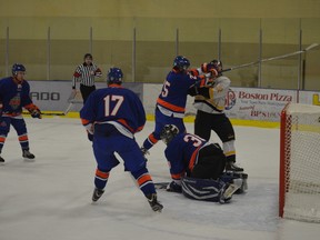 Stony Plain Eagles forward Scott Elkow takes a shot to the head from an Okotoks defender during a recent Chinook Hockey League game at the Glenn Hall Arena in Stony Plain. - Thomas Miller, Reporter/Examiner