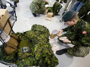 A Canadian Forces personnel posted at CFB Petawawa sorts out dry food items, prior to board a C-17 Globemaster at 8 Wing/CFB Trenton Ont.(Postmedia Network file photo)