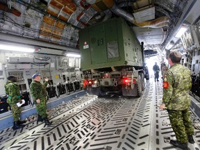 A military truck is being loaded into a C-17 Globemaster aircraft by members of 2 Air Movements Squadron, part of Canada's ongoing DART deployment to the Philippines, at 8 Wing/CFB Trenton, Ont. Friday, Nov. 15, 2013. - JEROME LESSARD /The Intelligencer/QMI Agency