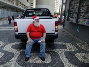 A student from the Brazilian Santa Claus school holds his diploma as he rests after the graduation ceremony in Rio de Janeiro, Nov. 12. The school holds four days' lessons in Santa-training, teaching Christmas carols, how to interact with children, and also how to wear the heavy red suit in Rio's typical 40C summer weather. 
QMI Agency/REUTERS/Pilar Olivares