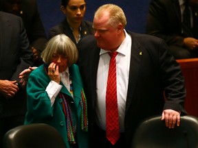 Councillor Pam McConnell nurses a fat lip while then-mayor Rob Ford hugs her after Ford barrelled into McConnell during a raucous city council meeting Monday, Nov. 18, 2013. (Dave Abel/Toronto Sun)