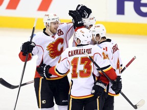 Nov 18, 2013; Winnipeg, Manitoba, CAN; Calgary Flames defenseman T.J. Brodie (center) celebrates his goal with teammates against the Winnipeg Jets during the second period at MTS Centre. Mandatory Credit: Bruce Fedyck-USA TODAY Sports