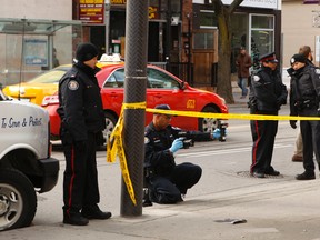The Toronto Police bomb squad was called to King St. W. and Peter St. early Tuesday to detonate a suspicious package found in the trunk of a car. Afterward, forensics officers snapped photos and gathered evidence the scene. (CHRIS DOUCETTE/Toronto Sun)