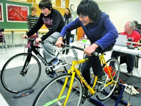 Jean Vanier separate school students Tadeo (right) and Colin use Computrainers and computer software that’s part of the Forest City Velodrome’s Youth Talent Identification Program to have a virtual cycling race Nov. 14, 2013. CHRIS MONTANINI/LONDONER/QMI AGENCY