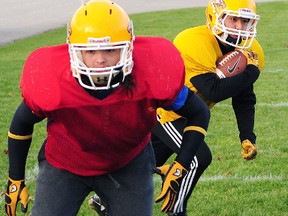 East Elgin running back Sean Lee totes the ball behind fullback Tim Janzen at practice Tuesday as the Eagles prepare for the TVRA Sr. B football championship game Saturday against the Clarke Road Trojans. Kickoff is 1 p.m. at TD Waterhouse Stadium in London.  R. MARK BUTTERWICK / Times-Journal / QMI AGENCY